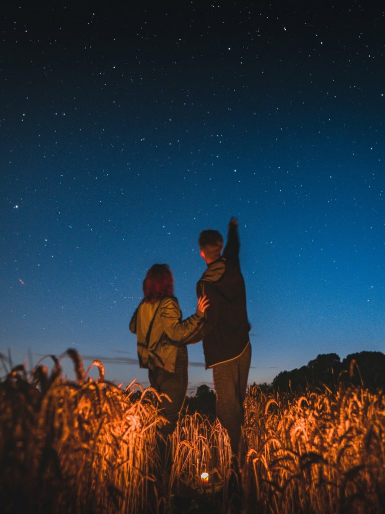 csillagos-eg-hatasa | Marie Claire Férfi és nő búzamezőn állva csillagokat néz