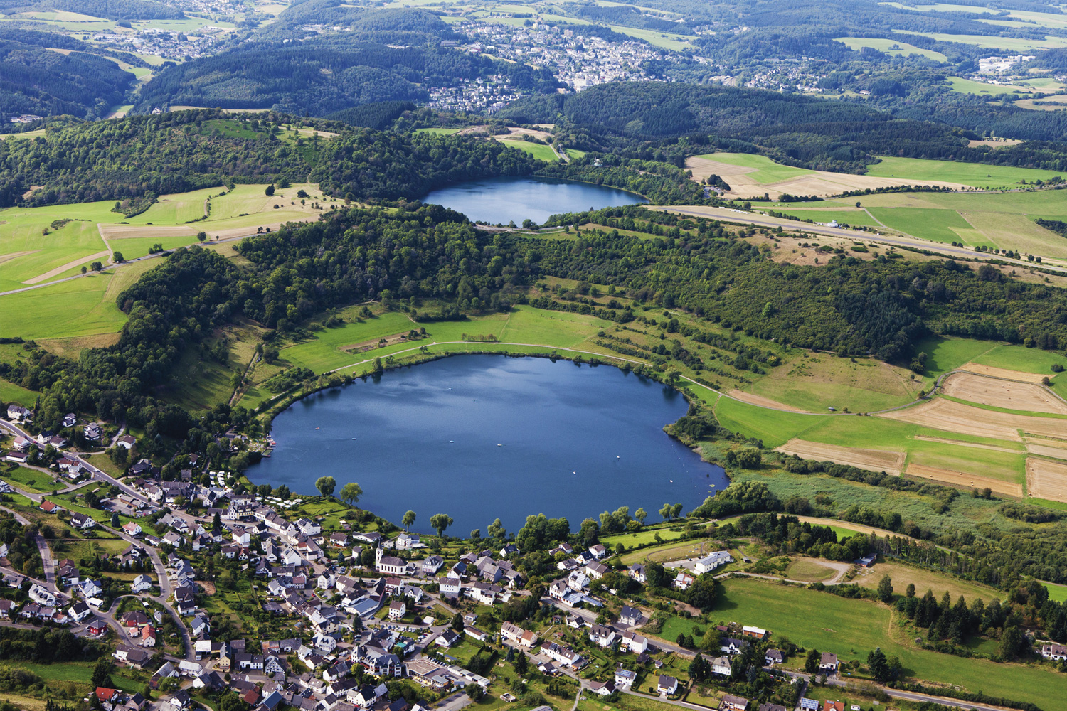 Eifel régió Németországban. Egy tó, körülötte házak és a természet.
