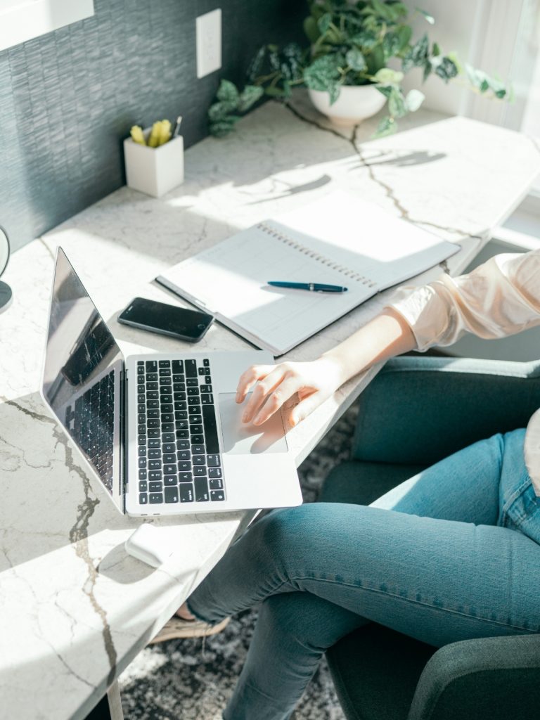 iroasztal-donteshozatal | Marie Claire Nő farmerben íróasztalnál ülve laptopon dolgozik