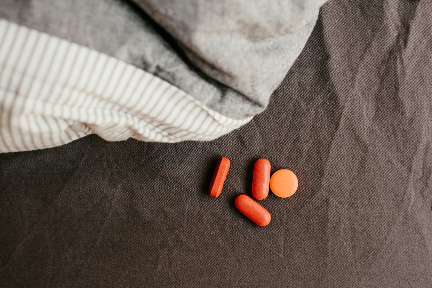 Melatonin és magnézium étrendkiegészítő fekete lepedőn takaró mellett