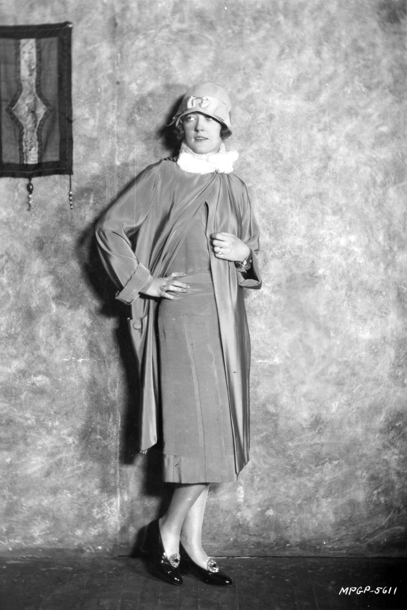 Marion Davies amerikai filmsztár 1920 körül, cloche kalapban és hosszú kabátban.
