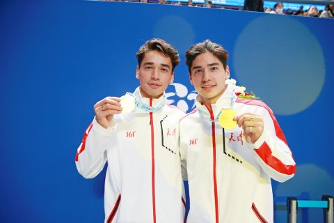 Liu Shaolin Sándor és Liu Shaoang kék háttér előtt, érmekkel