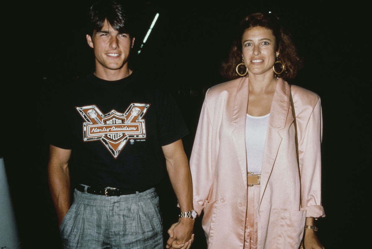 Tom Cruise pólóban és Mimi Rogers rózsaszín blézerben, kéz a kézben, 1980 körül.