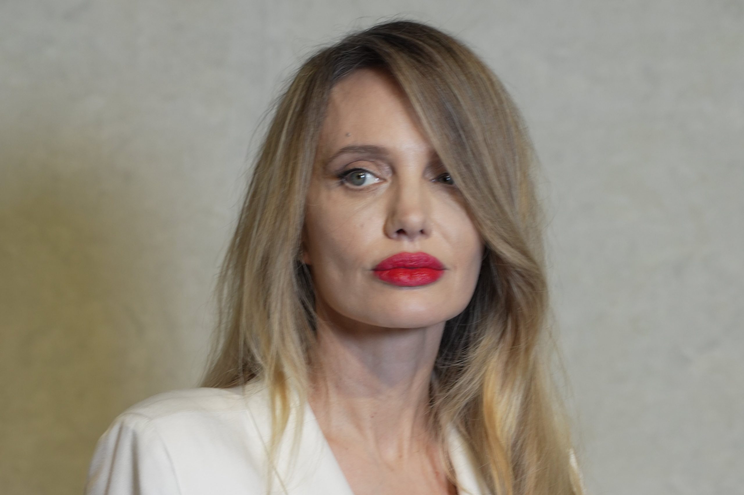 Angelina Jolie közelről, piros rúzzsal és fehér blézerben