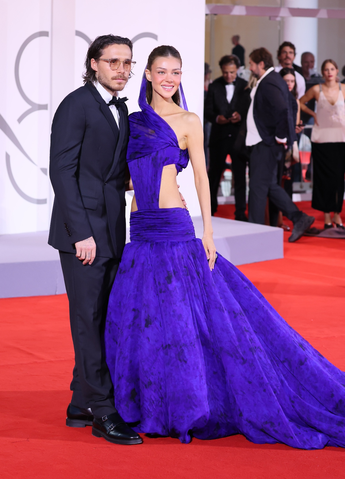 velencei-filmfesztival-brooklyn-beckham-nicola-peltz | Marie Claire Brooklyn Beckham szemüvegben és Nicola Peltz lila estélyiben a velencei vörös szőnyegen