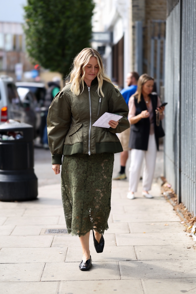 londoni-divathet-2026-streetstyle-ezt-viseljuk-osszel | Marie Claire Laura Weir olajzöld, bő ujjú bomberdzsekiben, olajzöld, áttetsző virágmintás csipke midiszoknyában és fekete bőrcipőben az Edeline Lee prezentációja előtt a londoni divathéten.