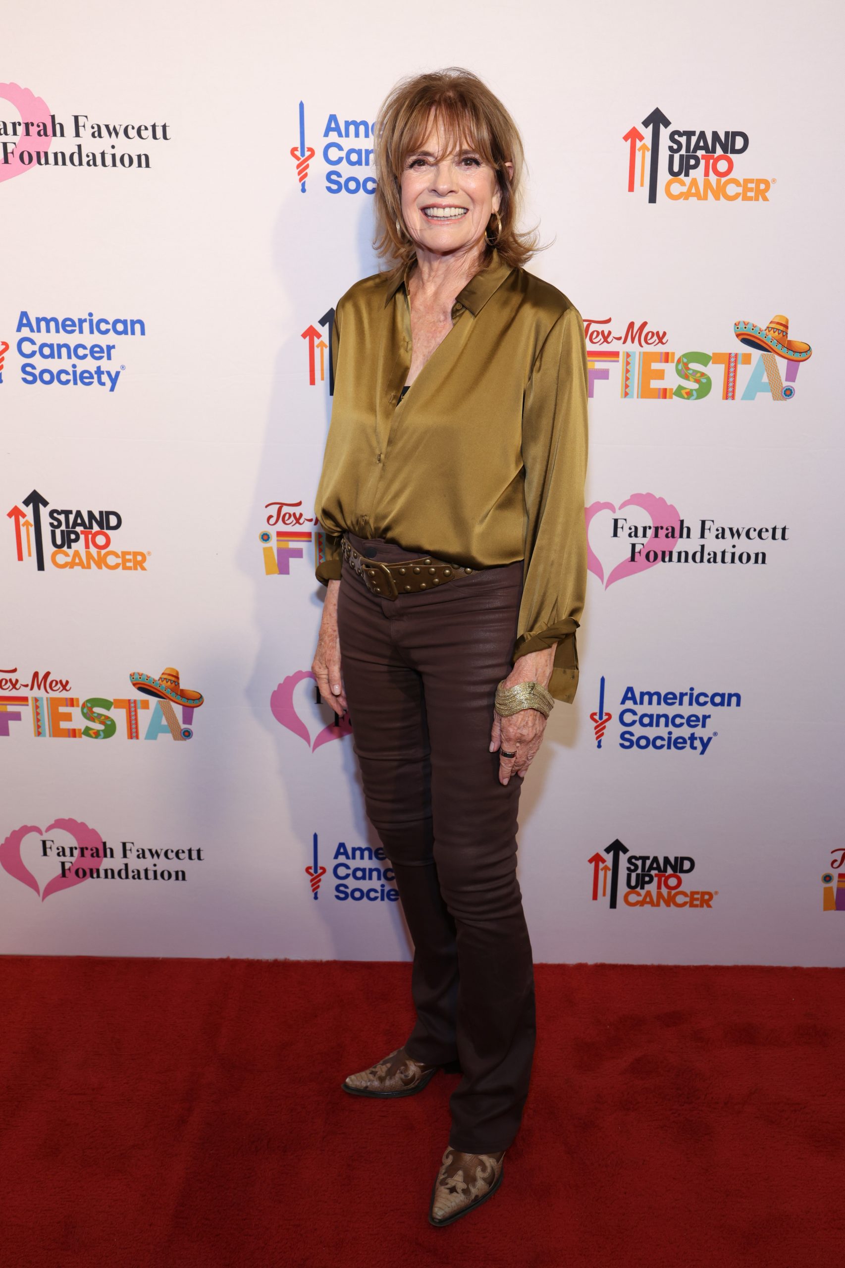 Linda Gray 86 évesen, zöld blúzban és nadrágban pózol