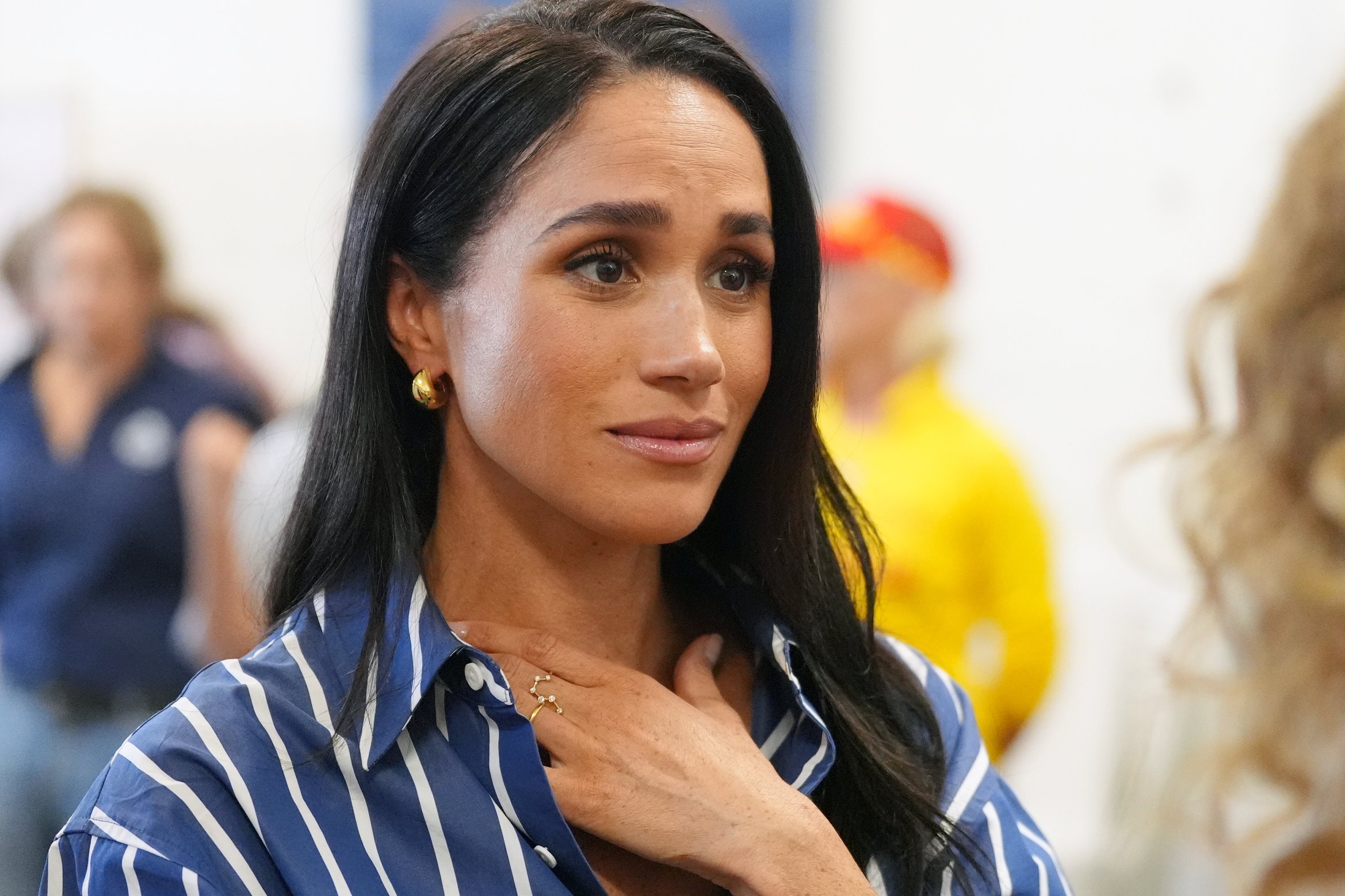 Meghan Markle kétségbeesett arccal, kék csíkos ingben