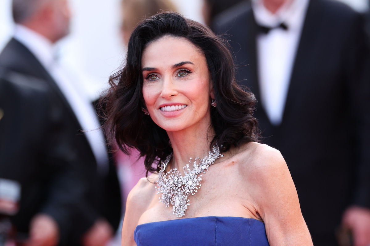 Demi Moore kék ruhában és hatalmas nyaklánccal, közelről