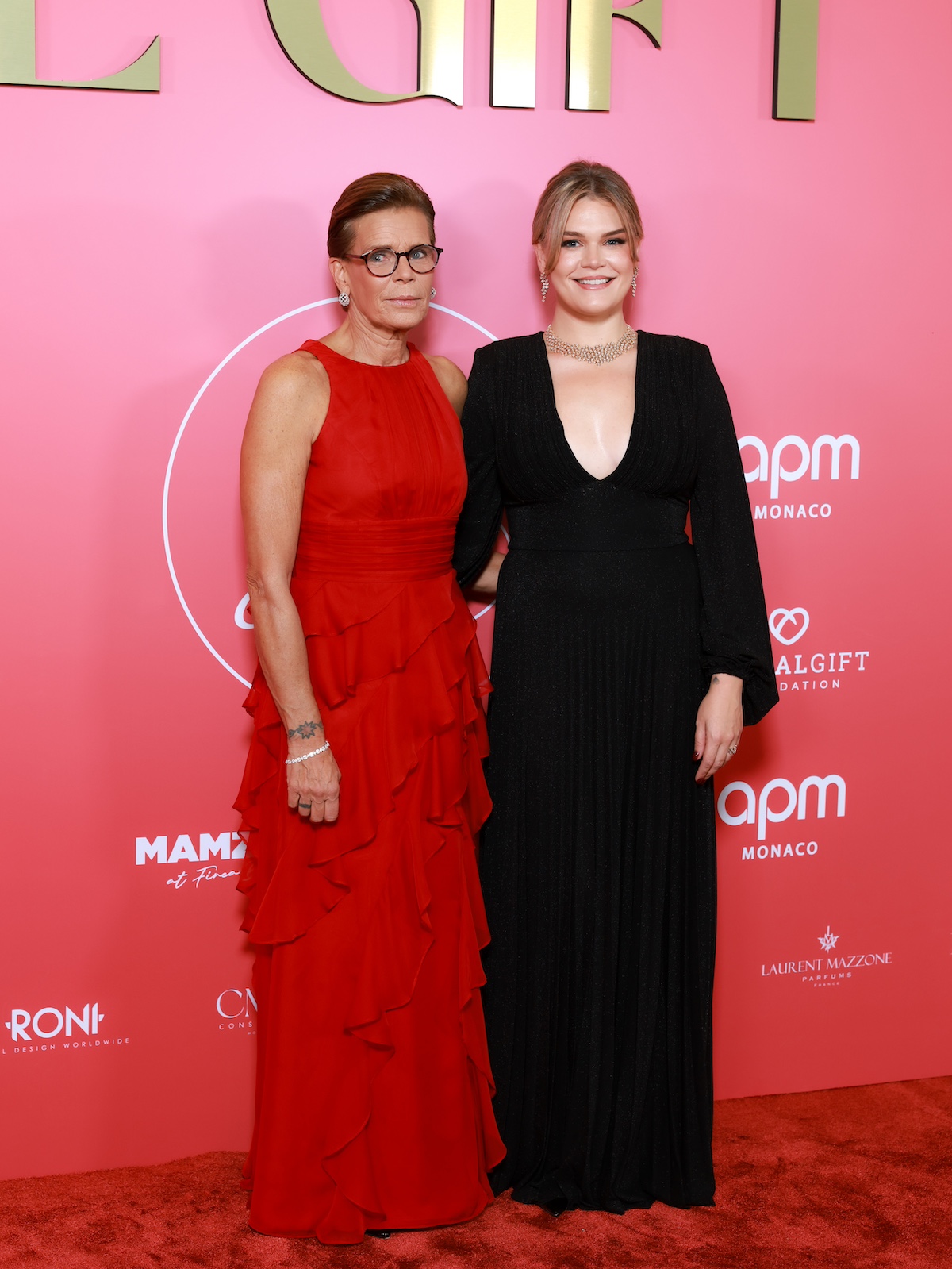 grace-kelly-unokaja-camille-gottlieb | Marie Claire Stéphanie monacói hercegnő piros és Camille Gottlieb fekete ruhában, rózsaszín háttér előtt