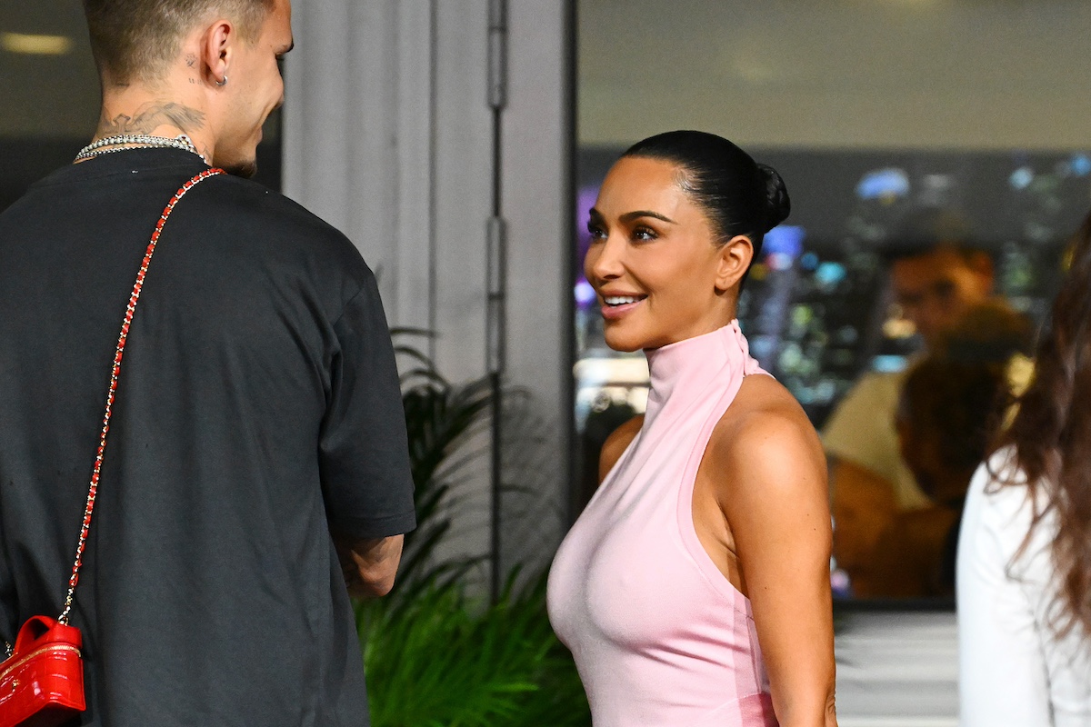 Kim Kardashian rózsaszín ruhában beszélget egy háttal álló férfival