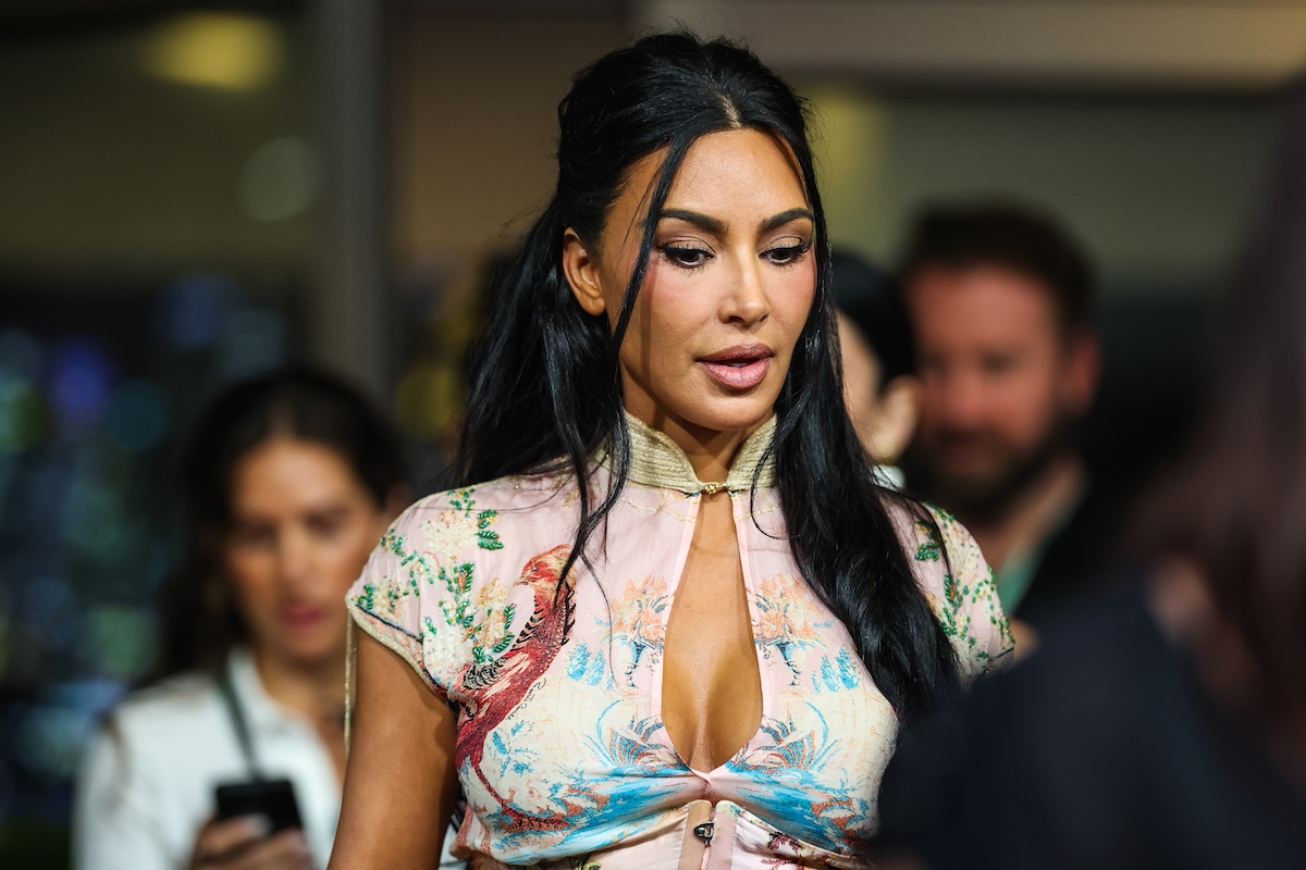 Kim Kardashian színes felsőben, kiengedett, de felül összekötött hajjal