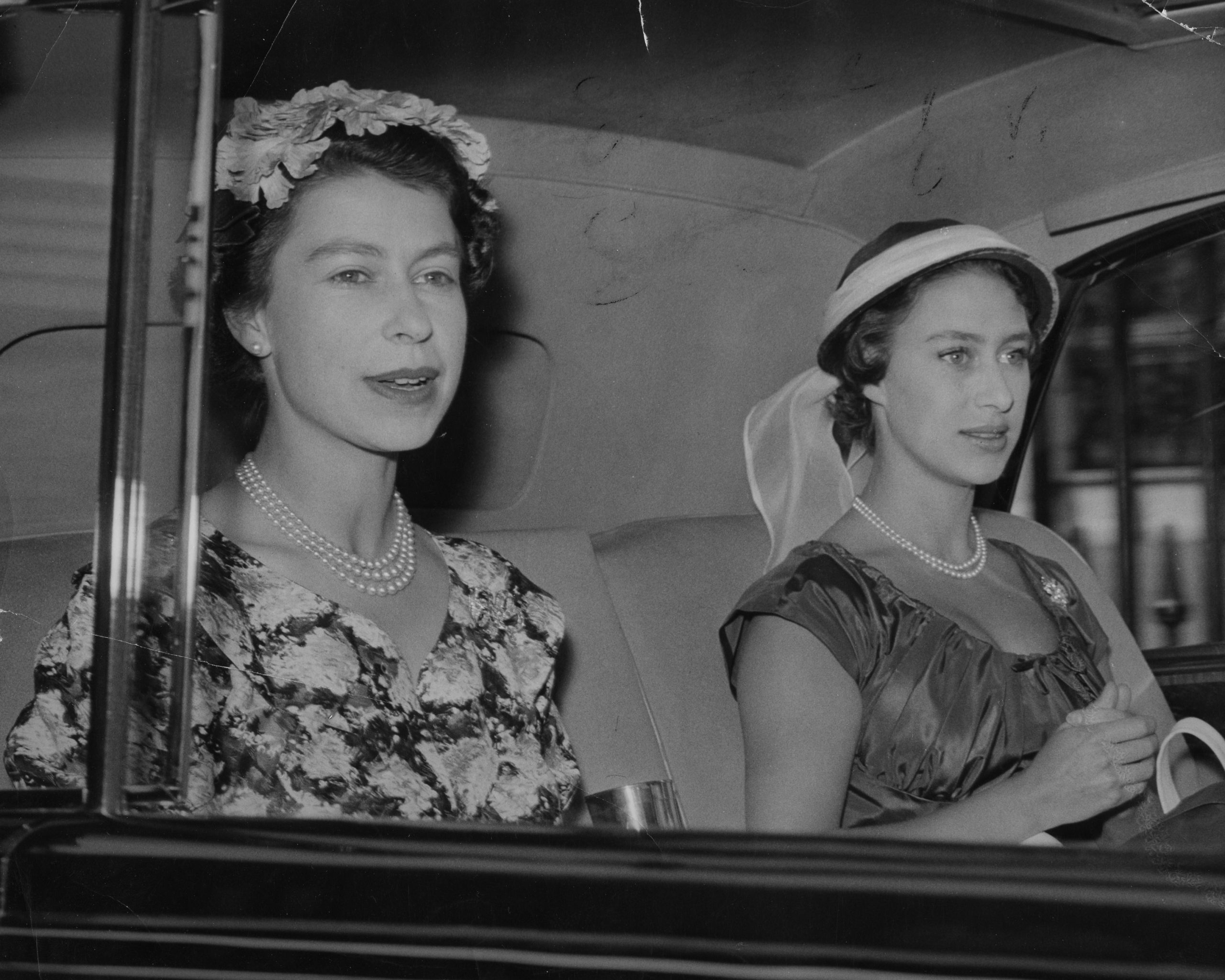 erzsebet-kiralyno-margit-hercegno | Marie Claire Erzsébet és Margit hercegnő a Buckingham-palotából indulnak autóval a Royal Ascot lóverseny első napjára – fekete-fehér fotó 1955-ből