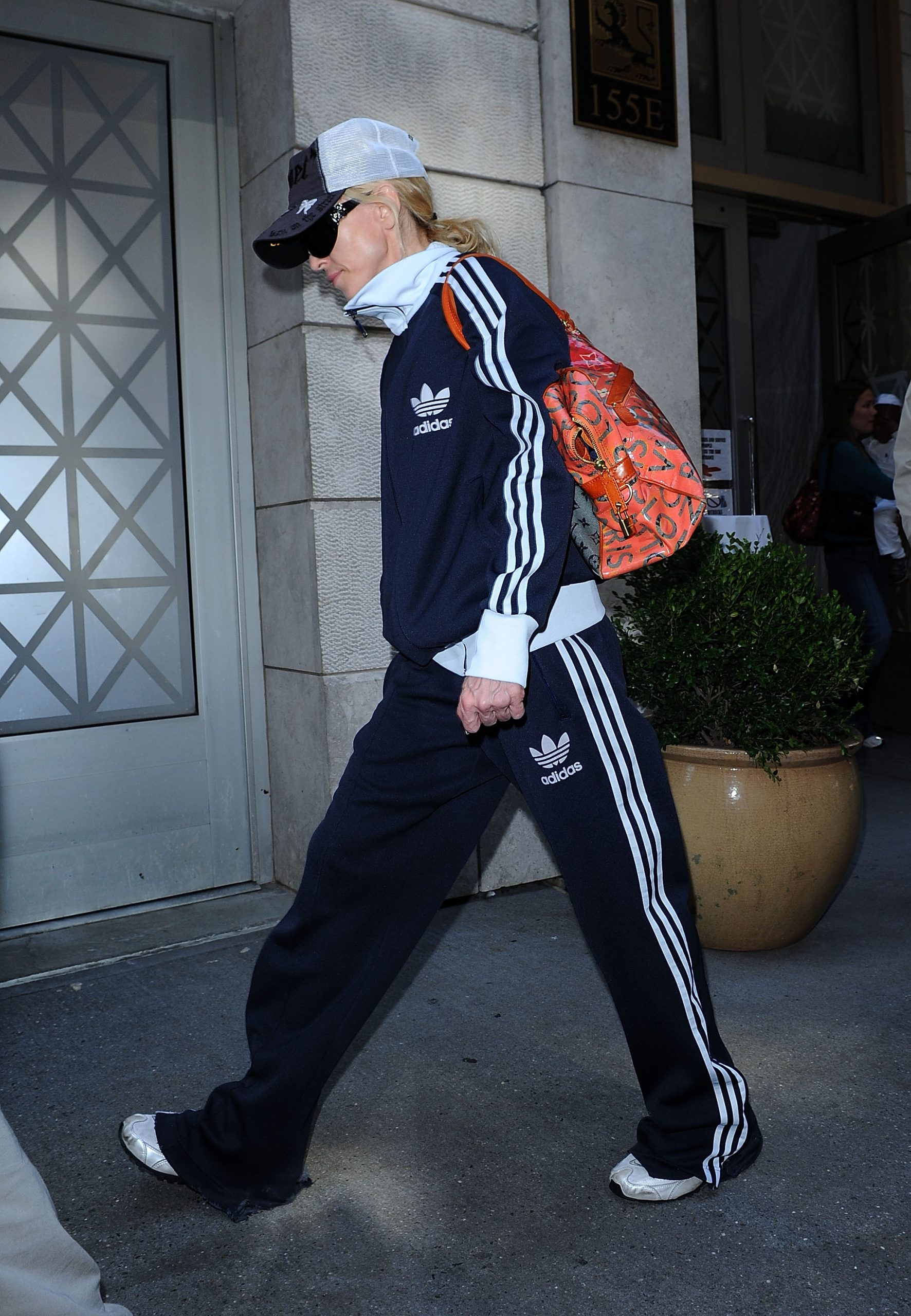 Madonna adidas melegítőszettben és piros táskával