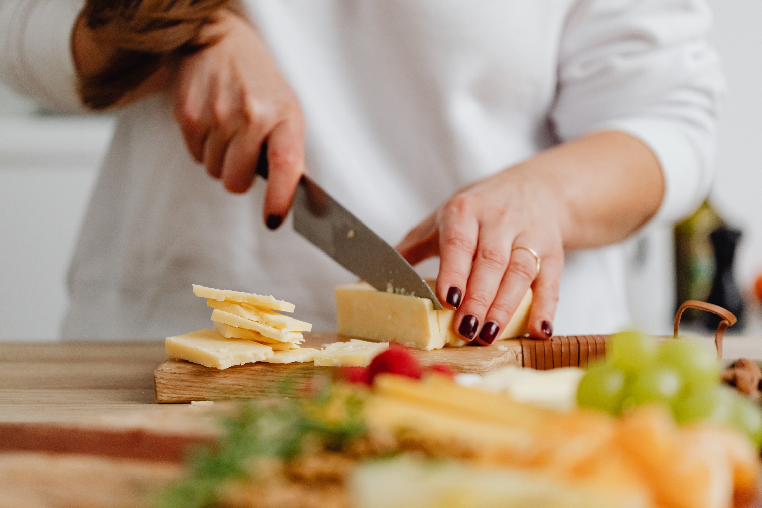 4. Főzés | Marie Claire Nő közeli képen sajtot aprít vágódeszkán