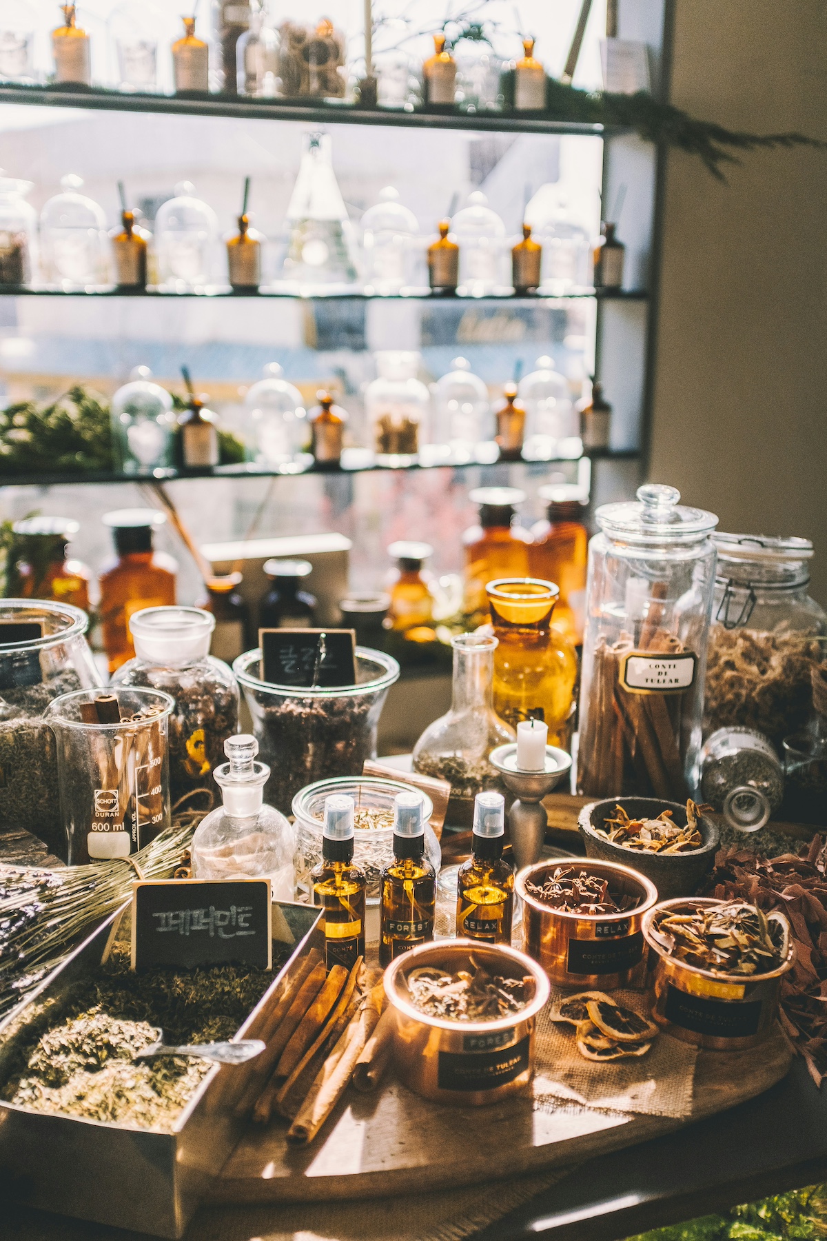 parfum-szavatossag | Marie Claire asztalon és polcokon parfümök, növények és illóolajok üvegekben