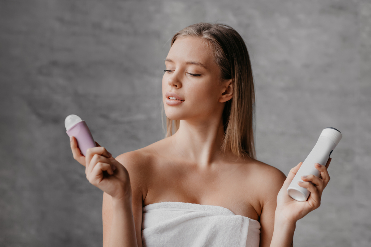 izzadasgatlo-este-mikor-hatasos | Marie Claire Törölközőbe csavart fiatal nő zuhany után a fürdőszobában golyós és spray dezodor között választ.