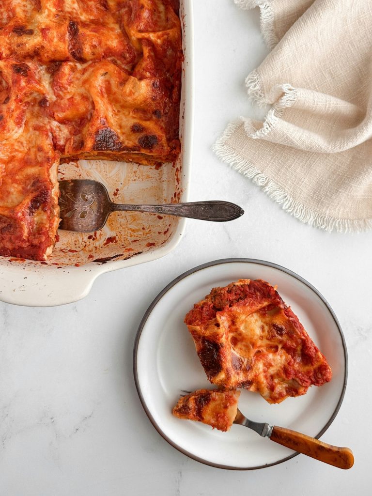 lasagne-hibak-sef-tanacsa | Marie Claire Felülnézetből egy tepsi lasagne, egy szelet mellette fehér tányéron