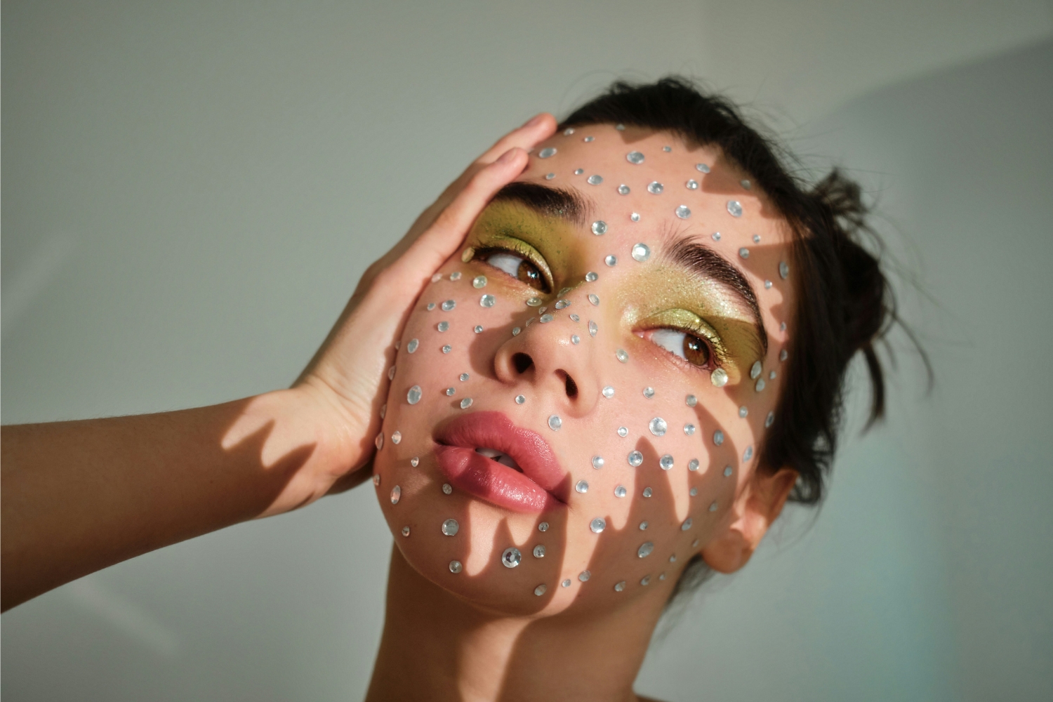 fiatal lány csillogó kövekkel az arcán, bedazzled trend